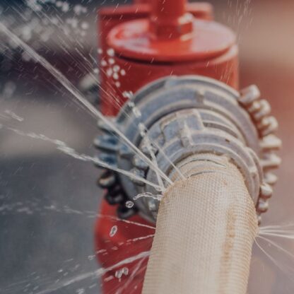 The flow of water and puddles from an open fire hydrant